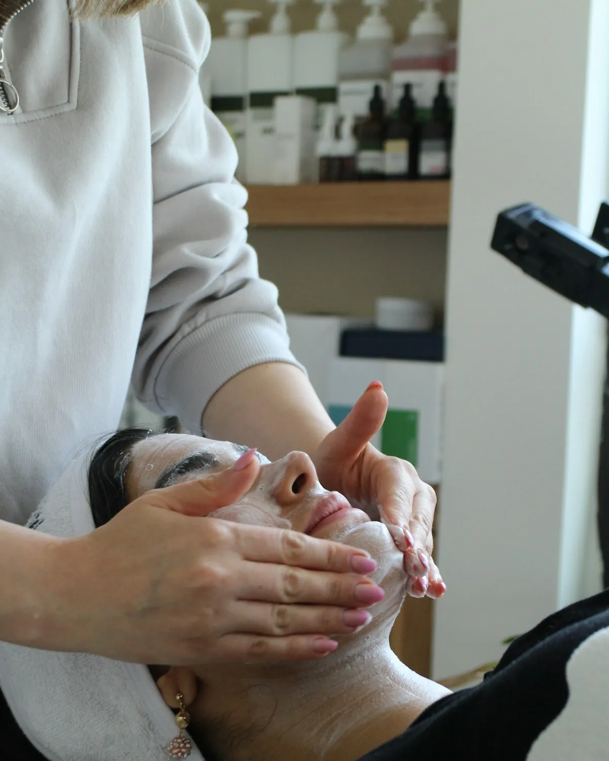 Profissional fazendo massagem facial em cliente